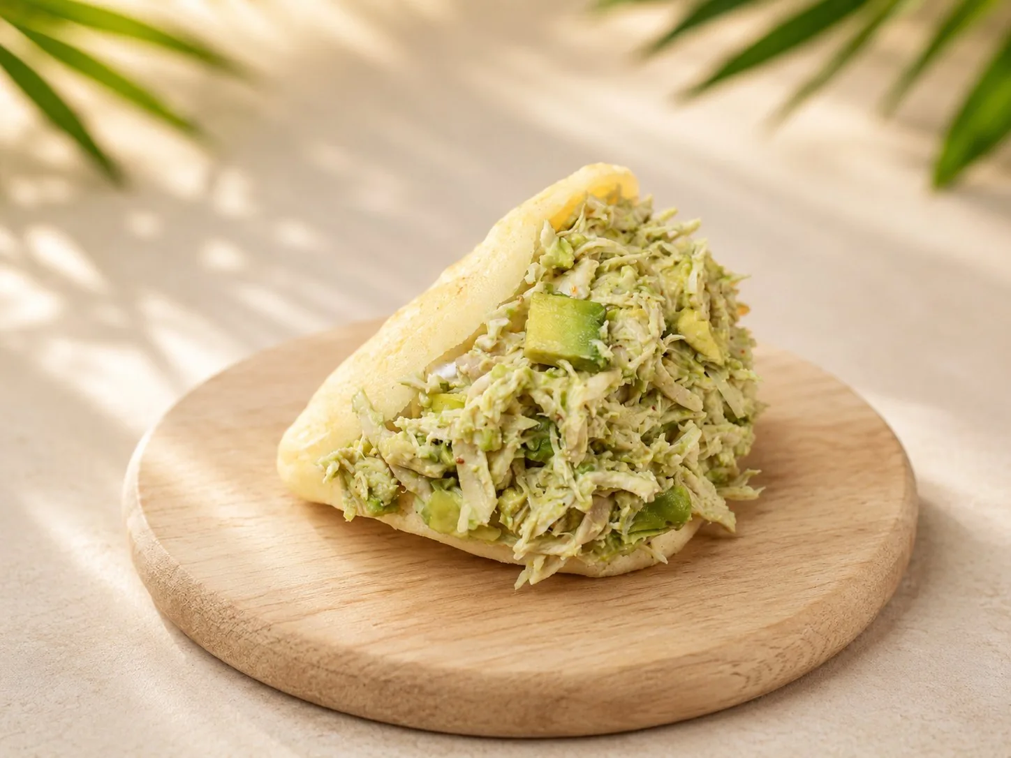 Arepa Reina Pepiada rellena con pollo desmechado, aguacate y mayonesa.