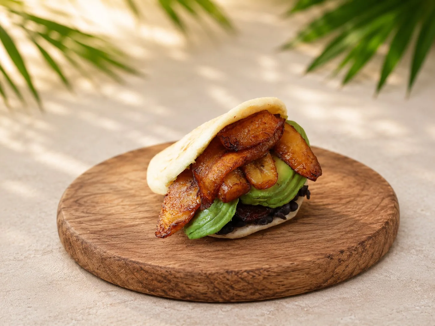 Arepa vegana con aguacate, tajadas y caraotas negras.