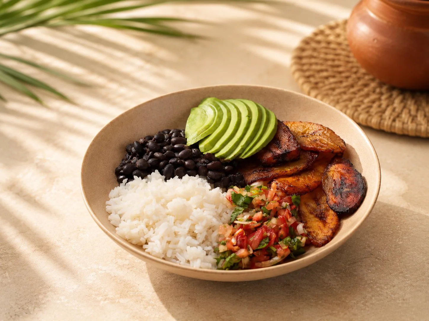 Bowl vegano con arroz, caraotas negras, aguacate, tajadas y pico de gallo.
